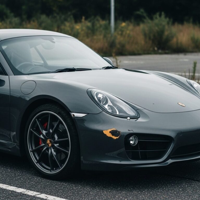 フロント部分に大きな擦り傷がついた黒いポルシェ